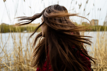 Woman shaking head with long hair outdoors