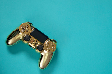 a gold video game controller on a blue background © yohanna