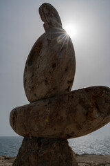 Sculpture symbol made of large pebbles against the blue sky