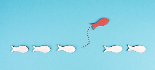 One red fish takes a different direction, leader of the group, leadership and teamwork concept, be...