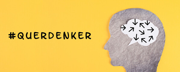 Think different stands in german language on the yellow background, head with brain, being a...