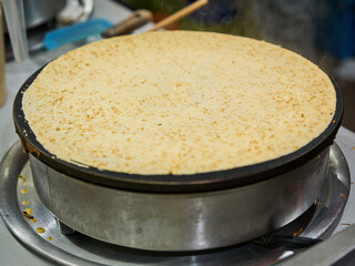 Making delicious crepes on a grill with fruit and chocolate