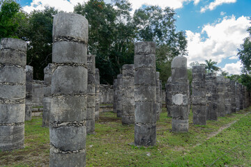 Columns of the Thousand Warriors in Chichen Itza, Yucatan, Mexico.  One of the new 7 wonders of the world. Rows of ancient stone columns on green grass.