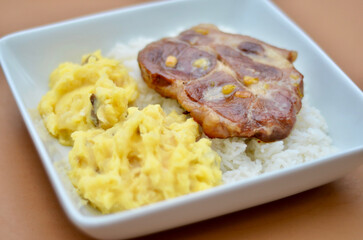 Pork Tenderloin Steak Medallion with Garlic, White Rice, and cheesy Pepper-seasoned Mashed Potatoes.