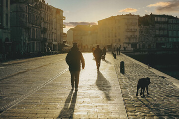 People walking on street during the sunset in the city of la Rochelle, France