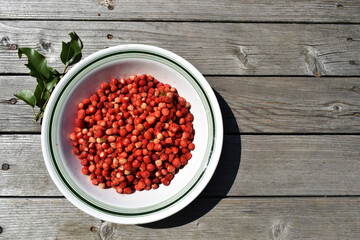 Fresh strawberries in a plate isolated on a wooden background. Top view of strawberries on the table. Summer fruits background, banner, copy space for text. View from above. Flat lay