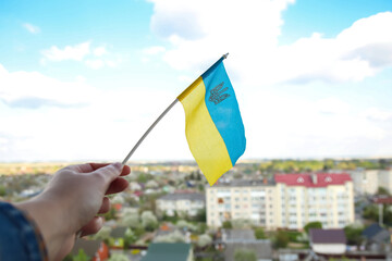 Defocus Ukraine flag. Large national symbol fluttering in blue sky. Support and help Ukraine, Independence Constitution Day, National holiday. Hand holding flag. Stop war. Out of focus