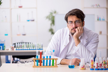 Young male chemist in drugs synthesis concept
