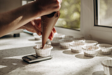 Fototapeta na wymiar Chocolate muffins. Homemade chocolate muffins. The process of making homemade chocolate cupcakes with whipped cream.
