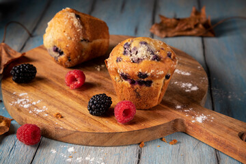 Fresh cupcakes and berry on wooden board