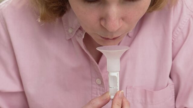 a woman collects saliva in a container for a dna test. 