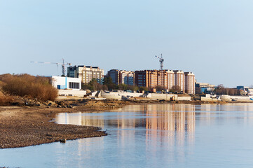 Obraz premium Embankment construction process. Earthworks and bank protection. Construction of capital reinforced concrete structures. The area of new buildings on the Zeya River.
