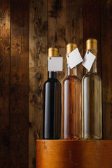 250 ml bottles with blank label on wooden background. Red, pink and white wine assortment. Mockup...