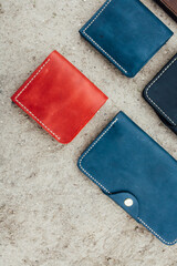 wallets of different colors of leather lie on the sand folded in a collage