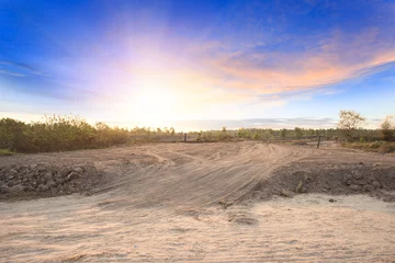 Fotobehang Empty dry cracked swamp reclamation soil, land plot for housing construction project with car tire print in rural area and beautiful blue sky with fresh air Land for sales landscape concept © Gan