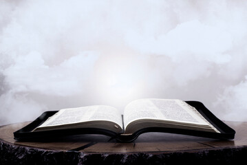 Open Bible. Holy Scripture. Book in the clouds. Gospel