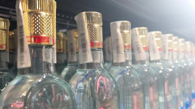 Rows of vodka bottles stand on the shelves of a liquor store (ABC store). Closeup
