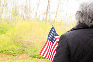 Woman holding American flag with yellow background