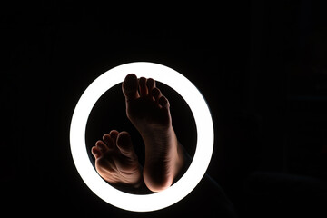 female legs close-up in a round lamp.the concept of hygiene and care.foot fetishism. - obrazy, fototapety, plakaty