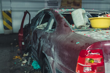 devastated car full of trash in the underground parking lot. High quality photo