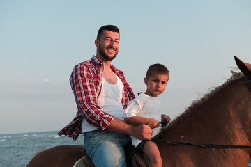 Father and son enjoy riding horses together by the sea. Selective focus 