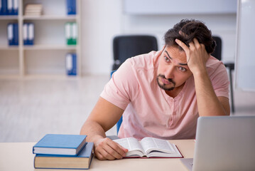 Young male student preparing for exams in the classroom