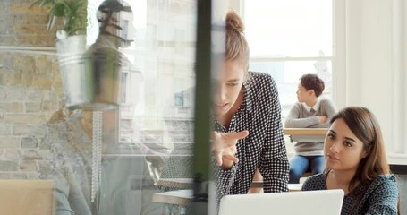A group of diverse businesspeople talking and brainstorming during a meeting using a laptop. Young businesswoman talking to staff team collaborating with colleagues. Coworkers in a business meeting