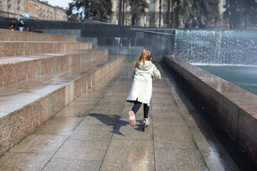 happy little cute girl having fun in splashes a fountain