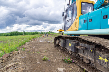 preparation for construction work, crawler construction equipment stands on a stone embankment,...