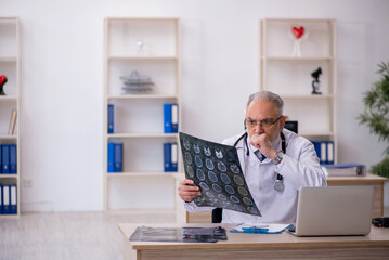 Old male doctor radiologist working in the clinic