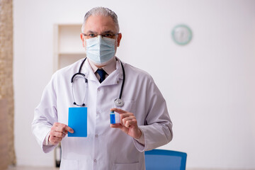Fototapeta premium Old male doctor in vaccination concept