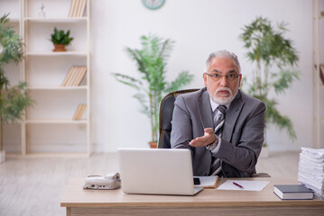Naklejka premium Old male employee and too much work in the office