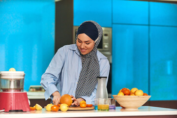  Arab hijab woman making fruit juice in modern kitchen. Home concept. Healthy lifestyle concept. Selective focus . High quality photo