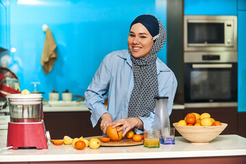  Arab hijab woman making fruit juice in modern kitchen. Home concept. Healthy lifestyle concept. Selective focus . High quality photo