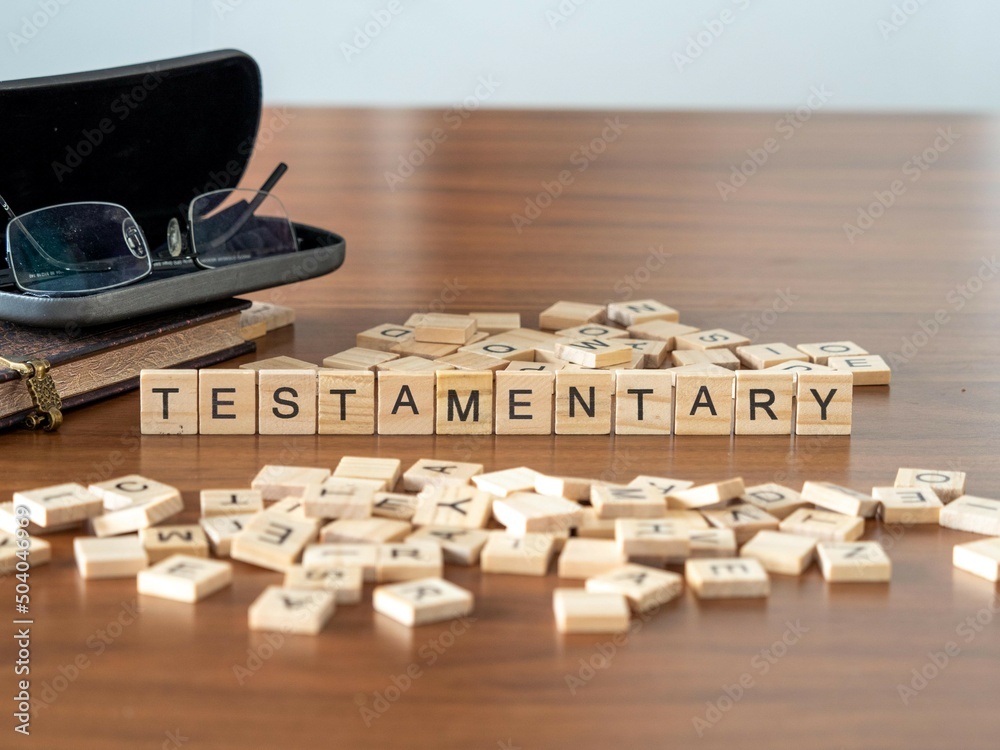 Canvas Prints testamentary word or concept represented by wooden letter tiles on a wooden table with glasses and a book