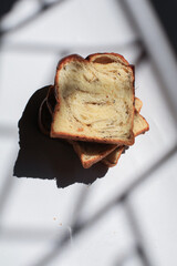 Sliced black truffle and cheese Brioche bread on white background under morning from window.