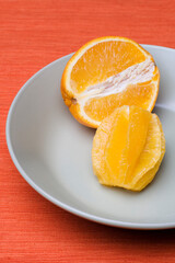 Fototapeta na wymiar Sliced orange pieces on grey plate