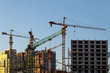 Fototapeta premium Construction cranes and high-rise buildings under construction