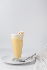 Mango latte and whipped cream and marshmallows in a glass cup, orange latte and cream, fruit latte