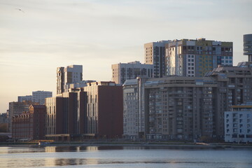 Obraz premium Full-color horizontal photo. Urban landscape. At sunset by the city pond in cloudy weather.