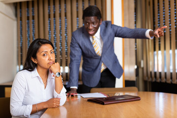 Angry boss blowing up female subordinate for mistakes in work