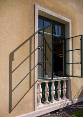 Obraz premium Turquoise Window Frames and Glass with a Shadow on a Yellow and White Building.