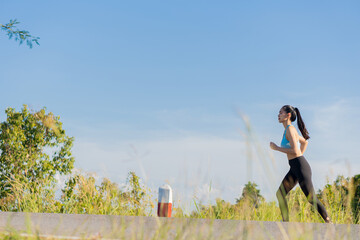 Portrait of an Asian woman exercising outdoors in a park, she is jogging for good health.