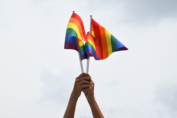 Rainbow flags, symbol of lgbt people, holding in hands, concept for calling, showing and respecting...