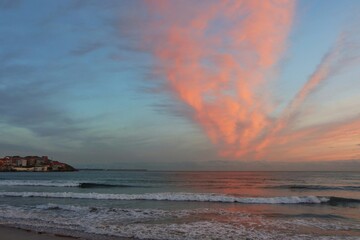 Amanecer con cielo naranja atravesando la playa