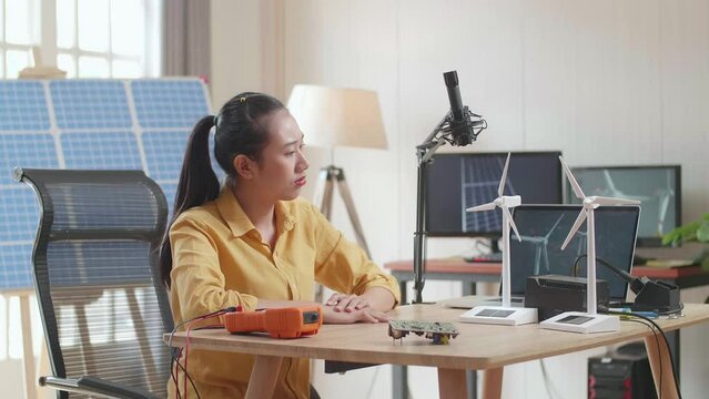 Asian Woman Being Upset Failing Testing The Wind Turbine While Working With Laptop Next To The Solar Cell At The Office
