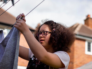 Girl hanging laundry in backyard