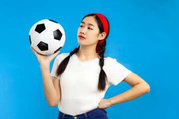 Asian Young woman over isolated blue background holding a soccer ball, football sport concepts