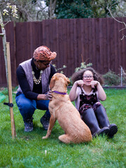 Mother and daughter with dog in backyard