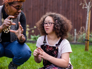 Mother and daughter talking in backyard